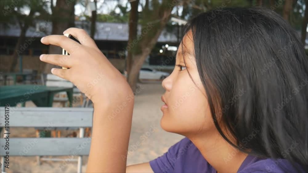 Asian children to using smart phone out door Asian children to using smart phone out door