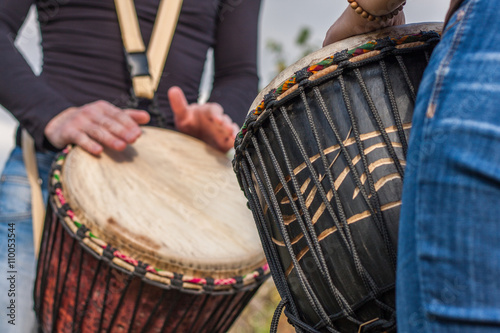 People hands playing music at djembe drums