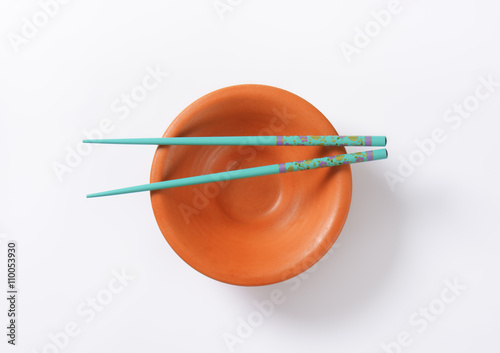 Blue chopsticks on a bowl