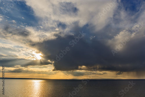rain cloud and the sun over the sea. © platonoo