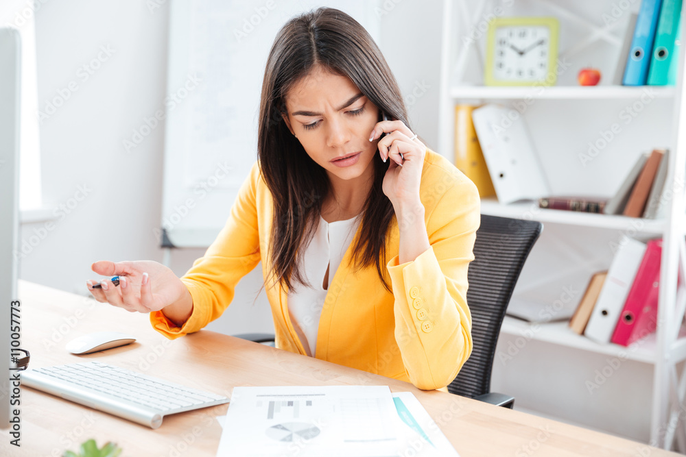 Businesswoman talking on the phone in office Businesswoman talking on the phone in office