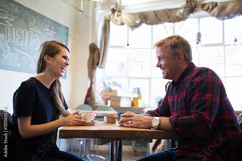 Father And Daughter Sitting At Table In Coffee Shop Together