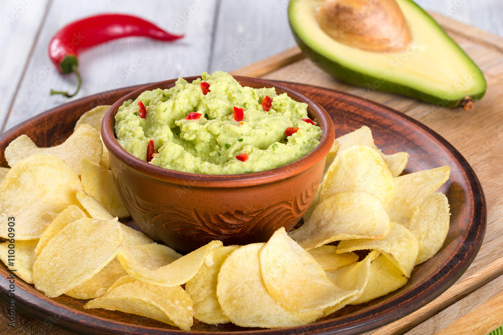 bowl of guacamole dip and potato chips bowl of guacamole dip and potato chips