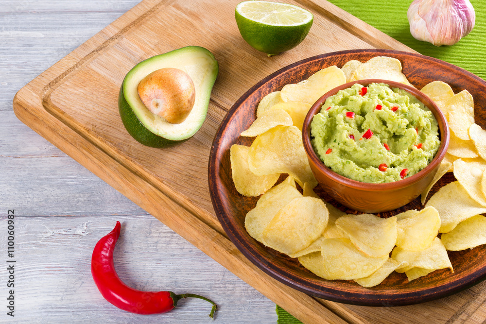 bowl of guacamole dip and potato chips
