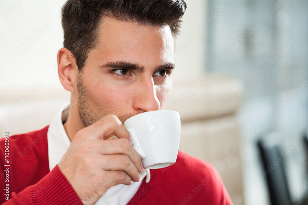 Young man is drinking coffee in a cafe. Young man is drinking coffee in a cafe.
