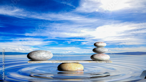 3D rendering of balancing Zen stones in water with blue sky and peaceful landscape.