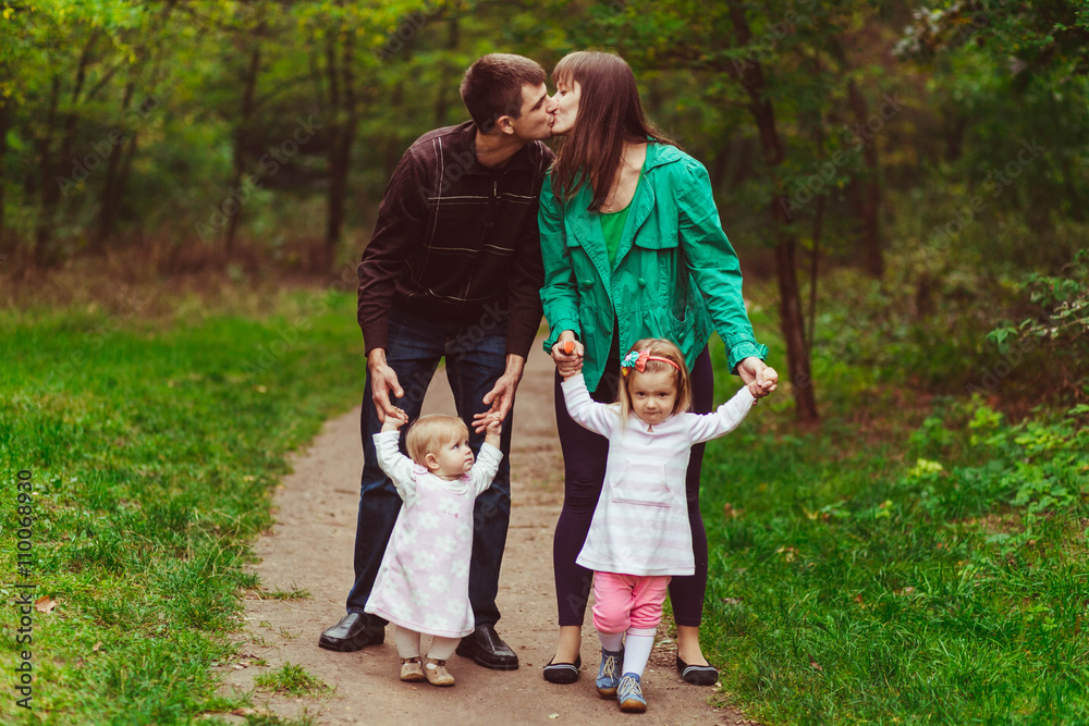 Fototapeta premium Young emotional family in the forest with kids