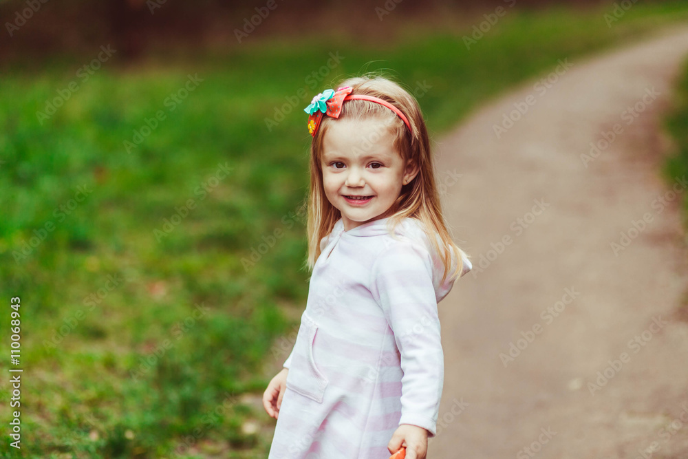 Fototapeta premium Little girl is walking in the wood