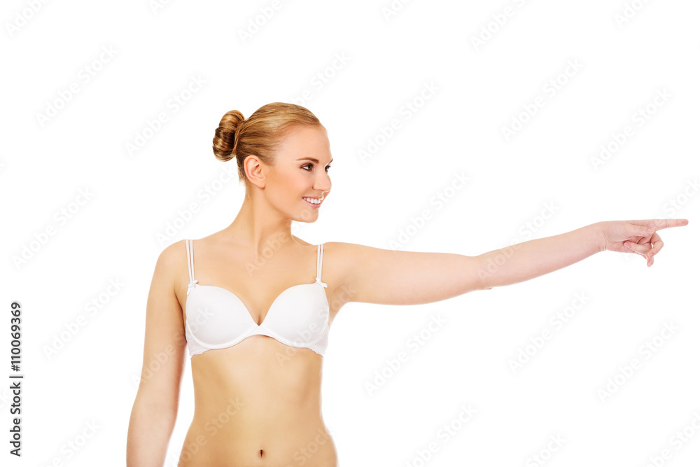 Young woman in white bra pointing for copyspace or something Young woman in white bra pointing for copyspace or something