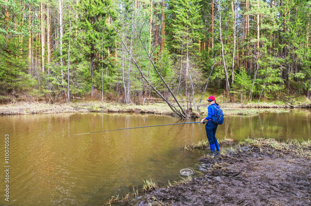  young woman catches fish in the early spring