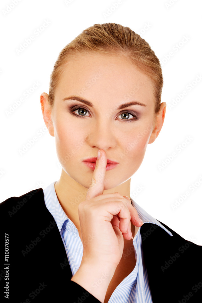 Business woman making silent sign with finger on lips Business woman making silent sign with finger on lips