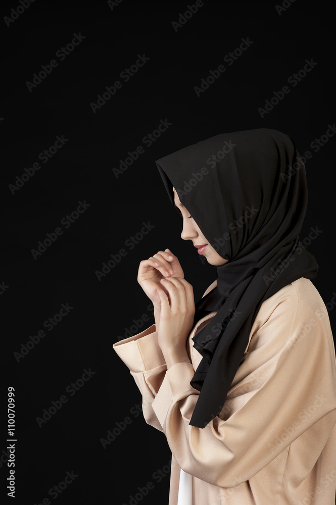 portrait in profile Beautiful Muslim girl in a black scarf on her head on a black  background Stock Photo | Adobe Stock