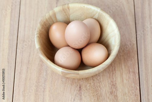 Eggs in bowl on wooden table