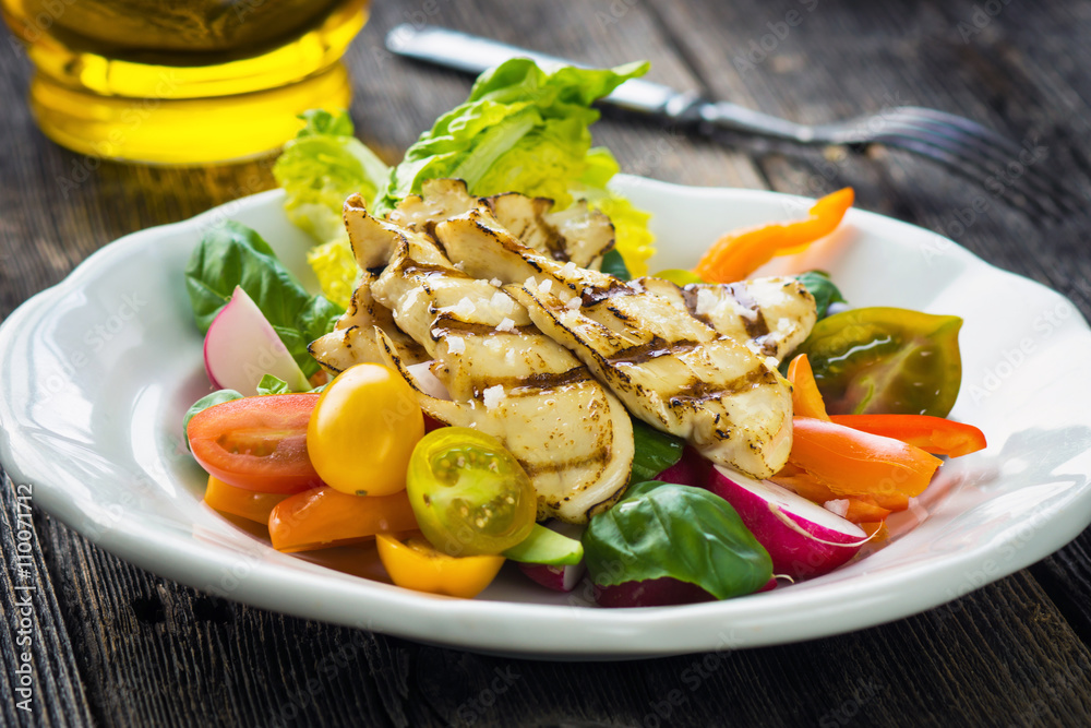 Delicious salad with grilled chicken breast on a wooden background Delicious salad with grilled chicken breast on a wooden background