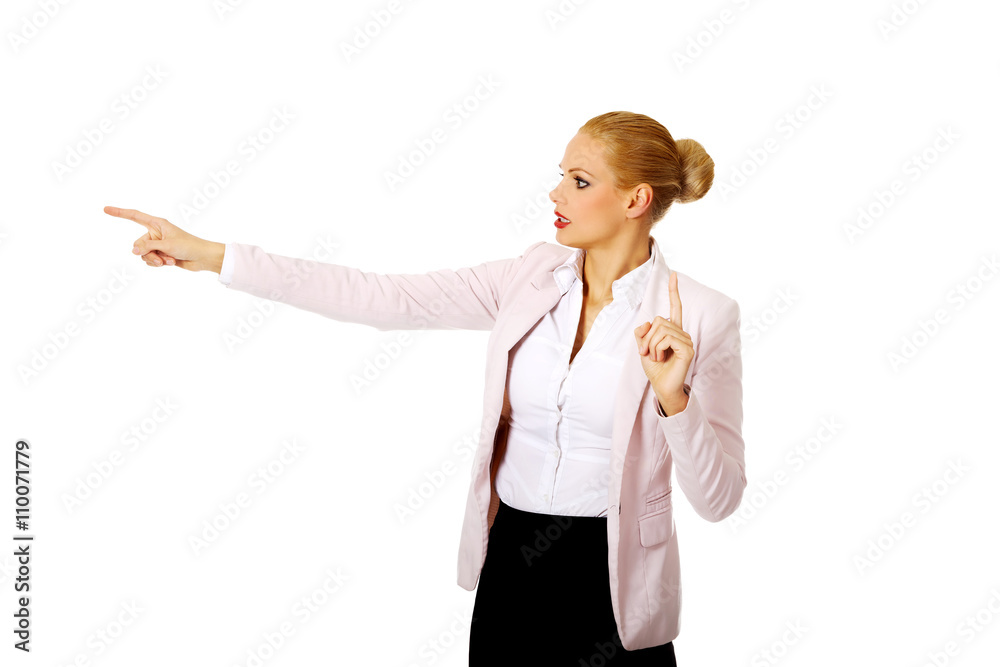 Young focus business woman explaining something and pointing at board or copyspace Young focus business woman explaining something and pointing at board or copyspace