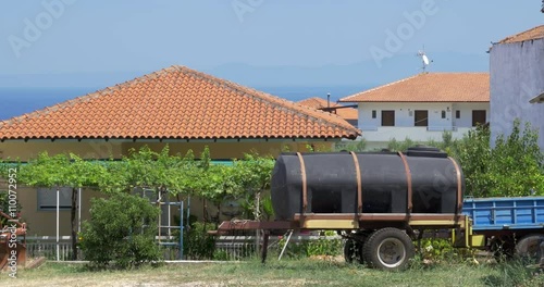 Water tank is standing on the backyard of cottage house on the seashore. photo