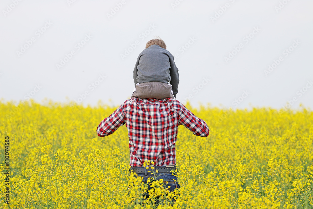 father with a sun in a a blossom yellow field