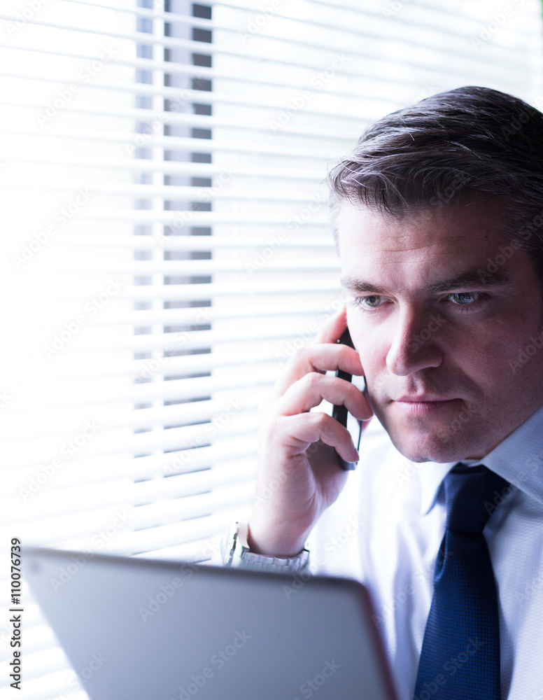 Real estate agent talking on the smartphone, holding a tablet, looking for the perfect home for his clients. Business, mortgage, brokerage, corporate and career concept Real estate agent talking on the smartphone, holding a tablet, looking for the perfect home for his clients. Business, mortgage, brokerage, corporate and career concept