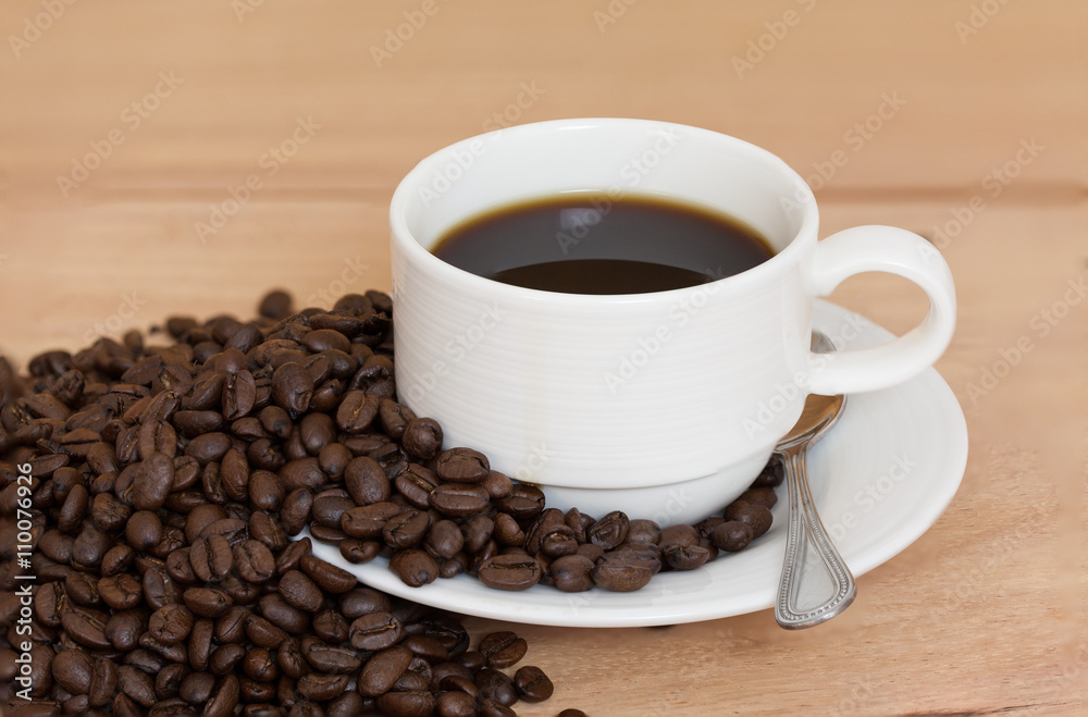 Coffee cup and coffee beans on table Coffee cup and coffee beans on table