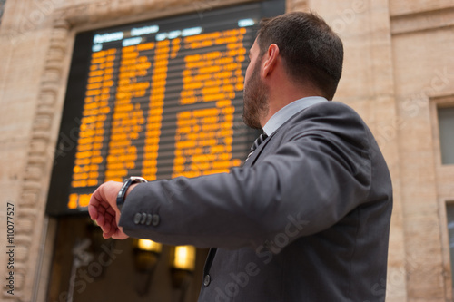 Obraz na plátně Man checking time while watching at a timetable