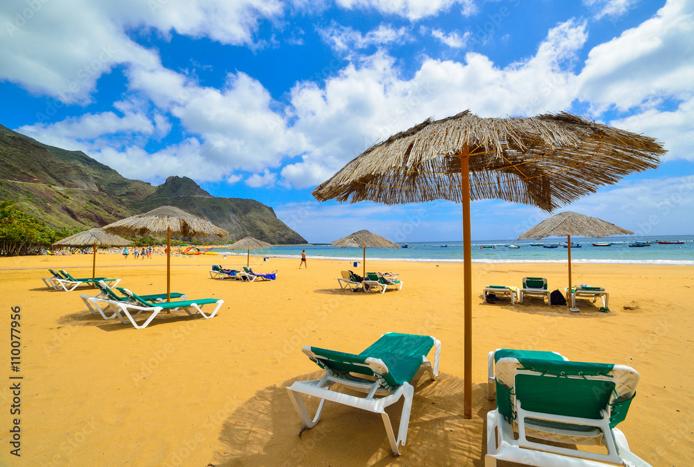 Chairs and umbrellas on Las Teresitas beach in summertime, Tenerife, Spain