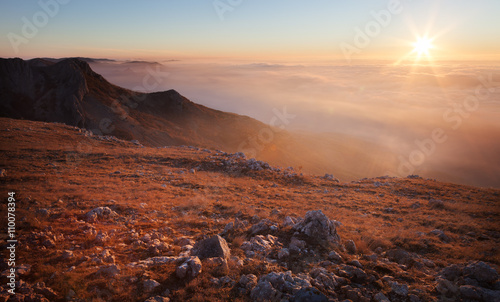 Mountain slopes in the mist at sunrise