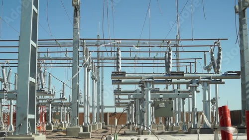 Long panning shot of an unfinished electrical substation under construction on the infrastructure grid used to generate, distribute and transmit electricity.