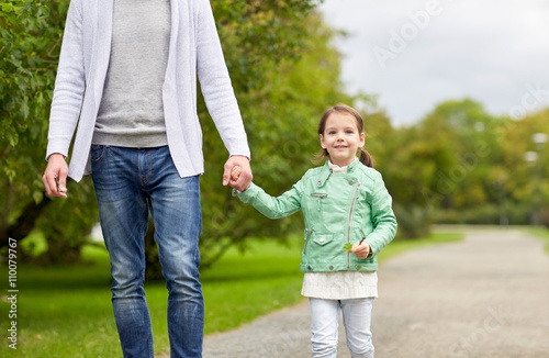close up of father and little girl walking in park