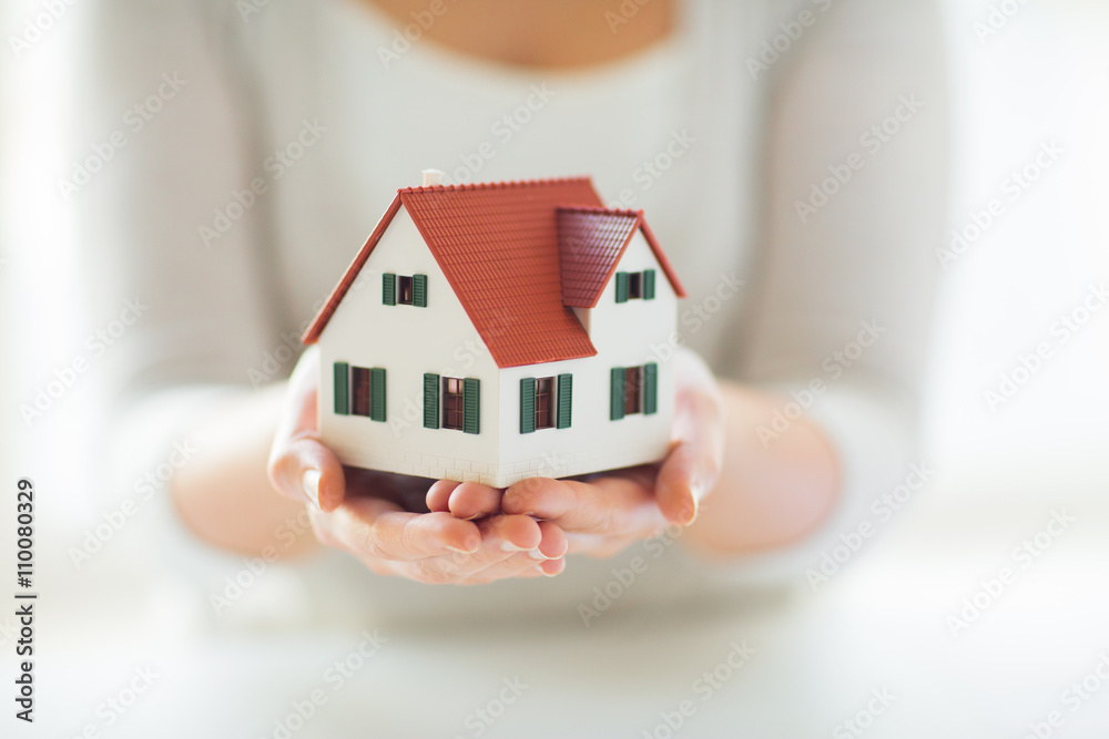 close up of hands holding house or home model close up of hands holding house or home model