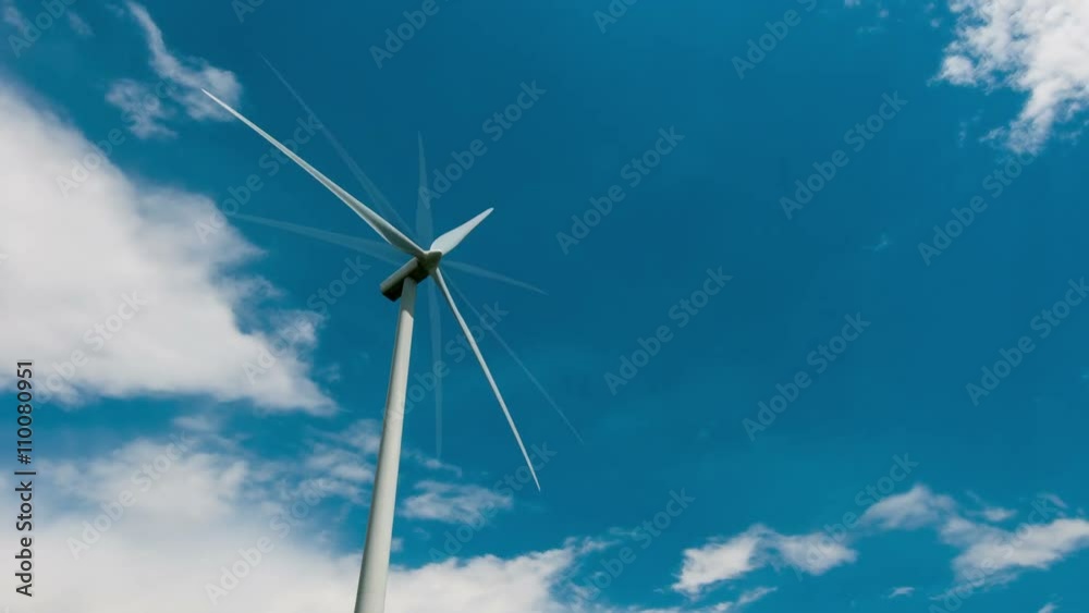 4k wind turbine generating electricity against the blue sky