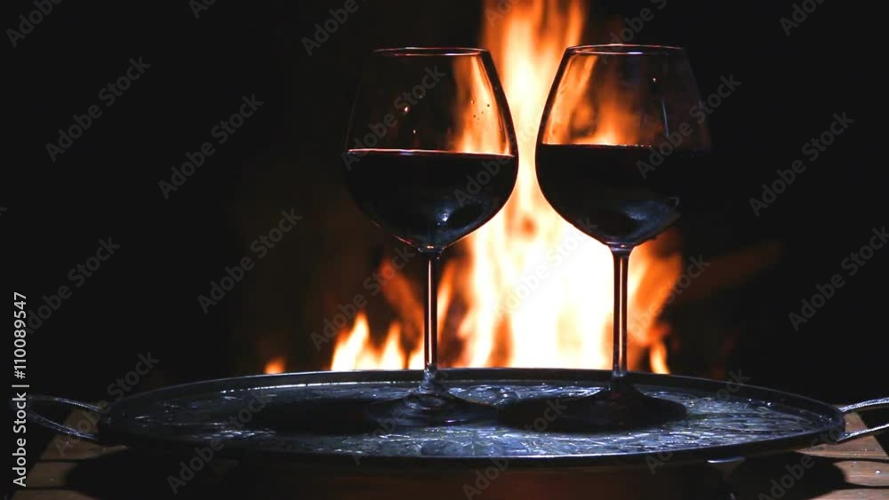Two glasses of wine with flame on background