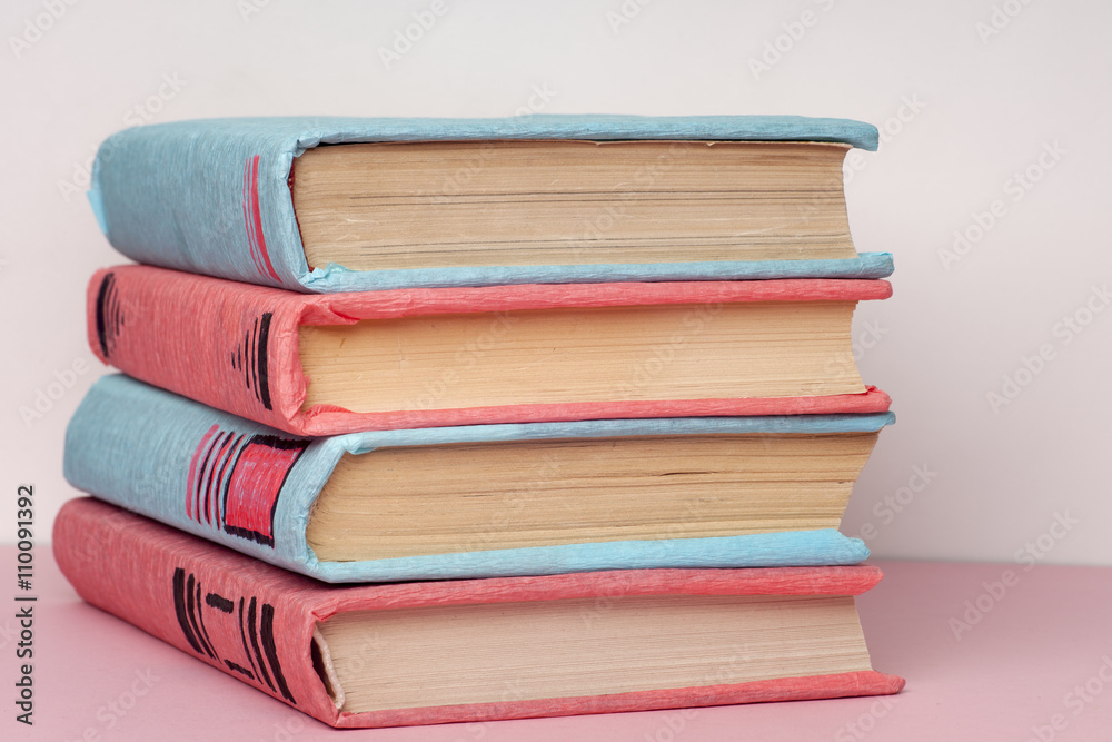 Stack of colorful books, grungy blue background, free copy space. Education essential for self improvement, gaining knowledge and success in our careers, business and personal lives. Stack of colorful books, grungy blue background, free copy space. Education essential for self improvement, gaining knowledge and success in our careers, business and personal lives.