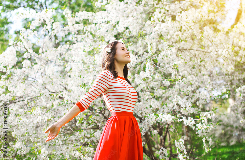 Beautiful happy woman enjoying smell in a flowering spring garde Beautiful happy woman enjoying smell in a flowering spring garde