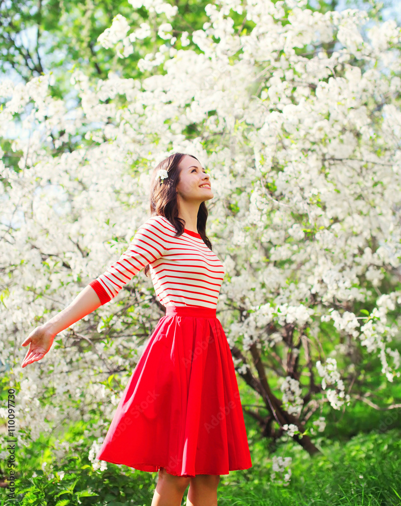 Beautiful happy young woman enjoying smell in a flowering spring Beautiful happy young woman enjoying smell in a flowering spring