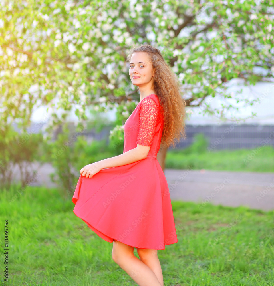 Beautiful young woman enjoying in flowering spring garden Beautiful young woman enjoying in flowering spring garden