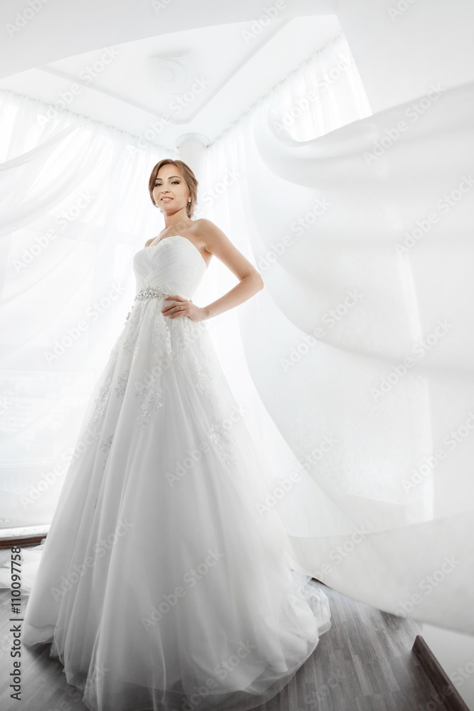 Fototapeta premium Brides beauty. Young woman in wedding dress indoors