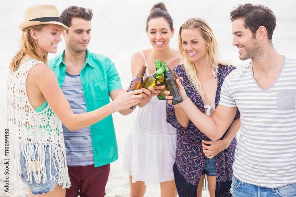 Group of friends toasting beer bottles on the beach Group of friends toasting beer bottles on the beach