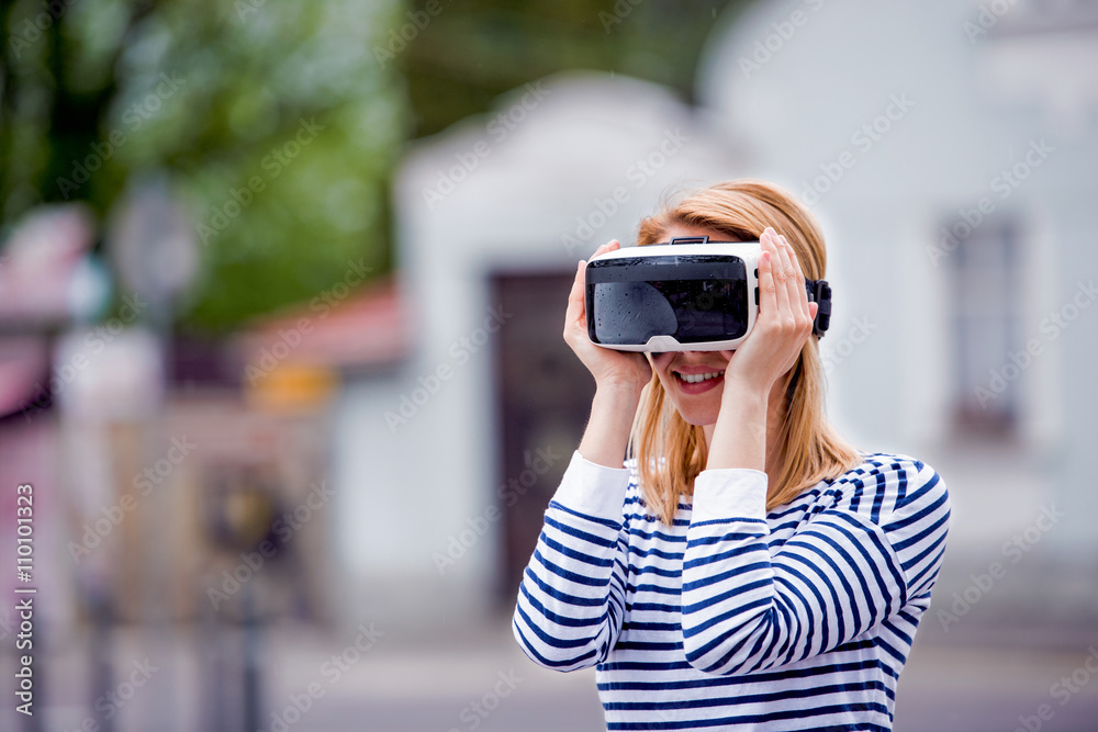 Woman wearing virtual reality goggles in the street