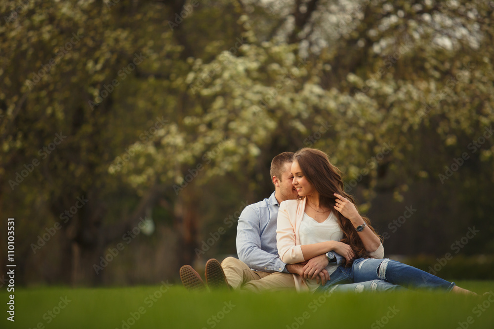 Happy Smiling Couple Relaxing on Green Grass.Park Happy Smiling Couple Relaxing on Green Grass.Park