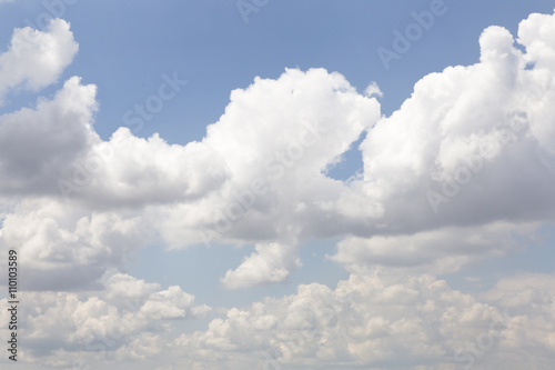 White fluffy clouds in the blue sky. The sky background