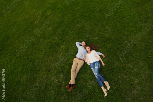 Happy Smiling Couple Relaxing on Green Grass.Park