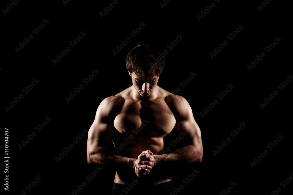 Fototapeta premium Muscular and fit young bodybuilder fitness male model posing over black background. Perfect fitness WET body with DROPS. Ideal for commercial. ABS