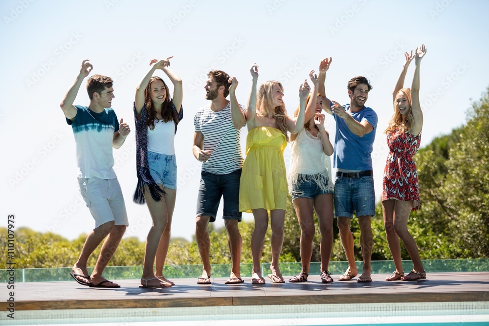 Obraz premium Happy friends dancing near the swimming pool