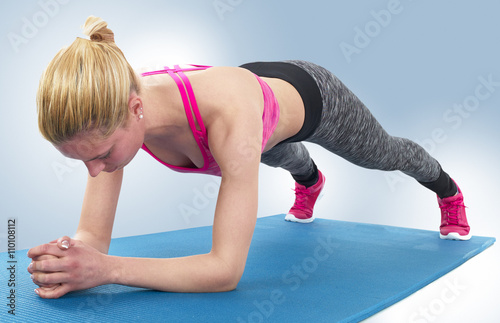 Athlete girl doing plank exercise.