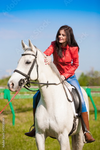 Woman sitting  horse. Day. Half height. Red leather jacket © erainbow