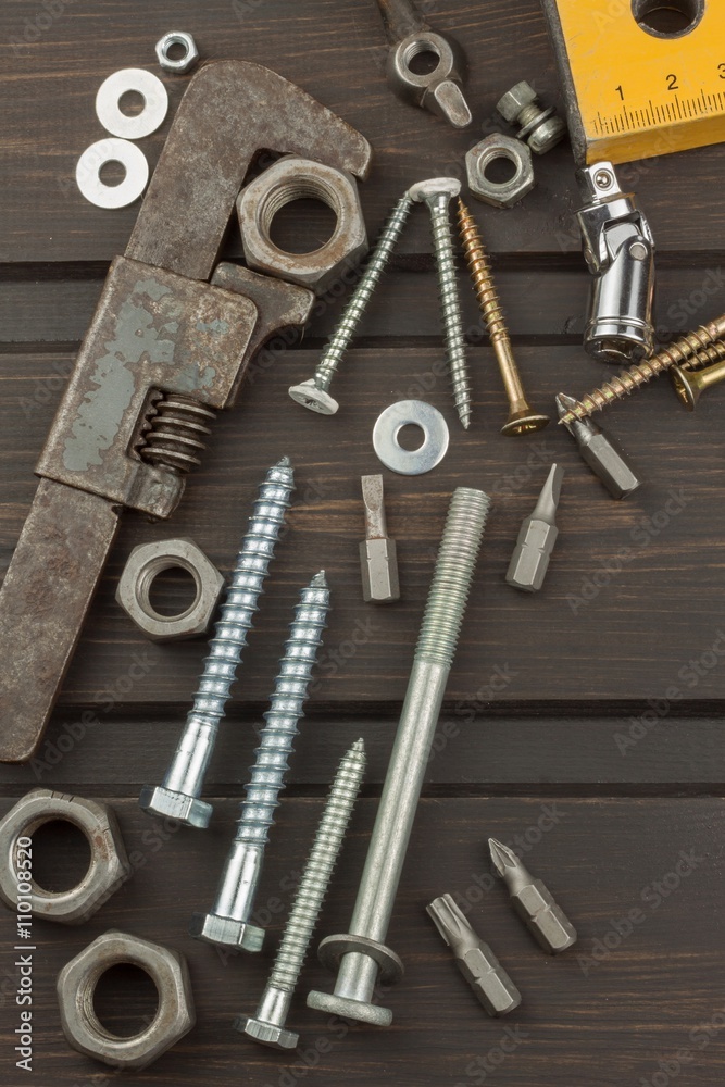 Fototapeta premium Disorder in the tool. Preparing for home treatment. Various tools, screws and nuts on a wooden background. Tool repairman.