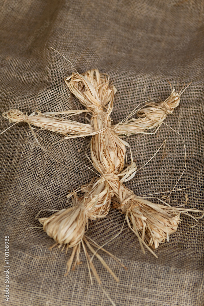 Raffia doll on a burlap fabric Raffia doll on a burlap fabric
