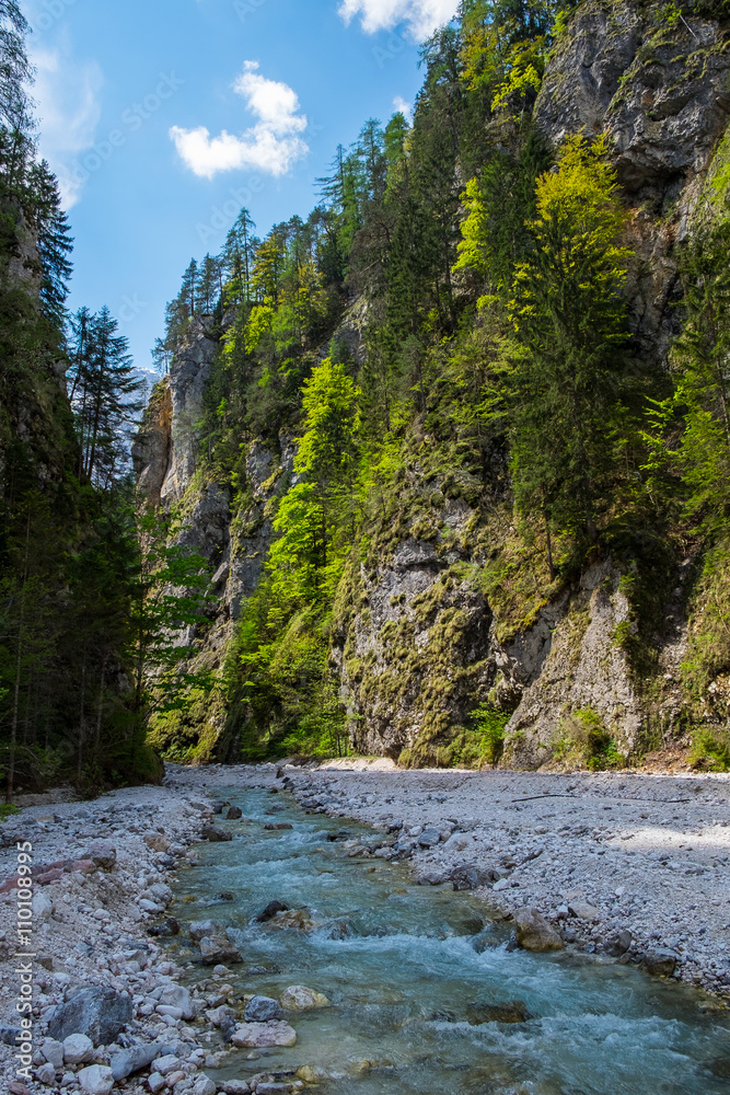 Mountain fast river stream in the rocks. Canyon with creek under blue sky. Pebble shore of brook. Mountain fast river stream in the rocks. Canyon with creek under blue sky. Pebble shore of brook.