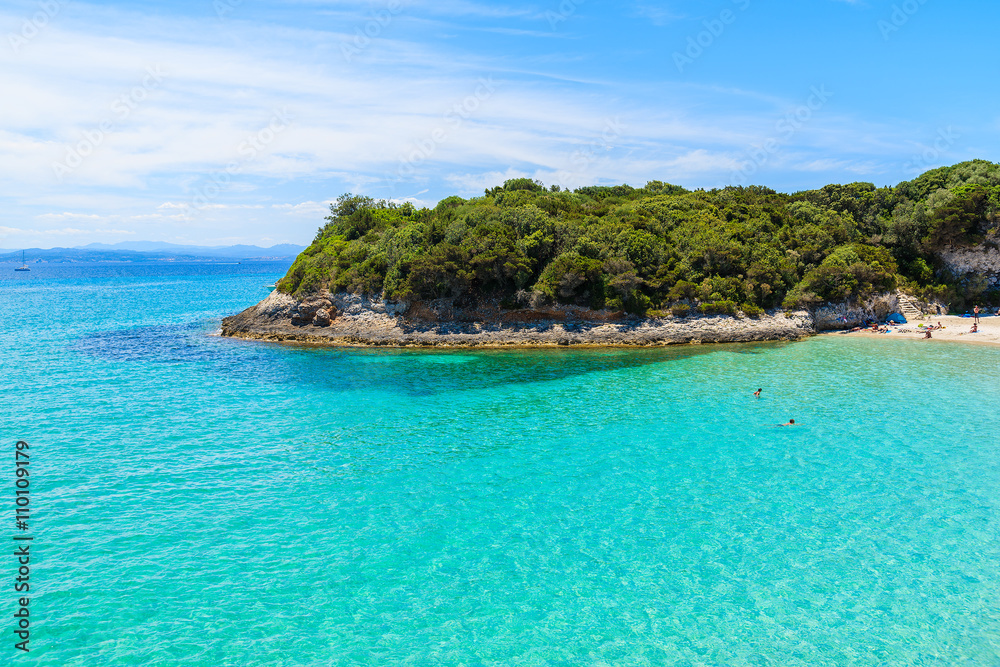 People swimming in beautiful bay with azure sea water, Petit Sperone beach, Corsica island, France People swimming in beautiful bay with azure sea water, Petit Sperone beach, Corsica island, France