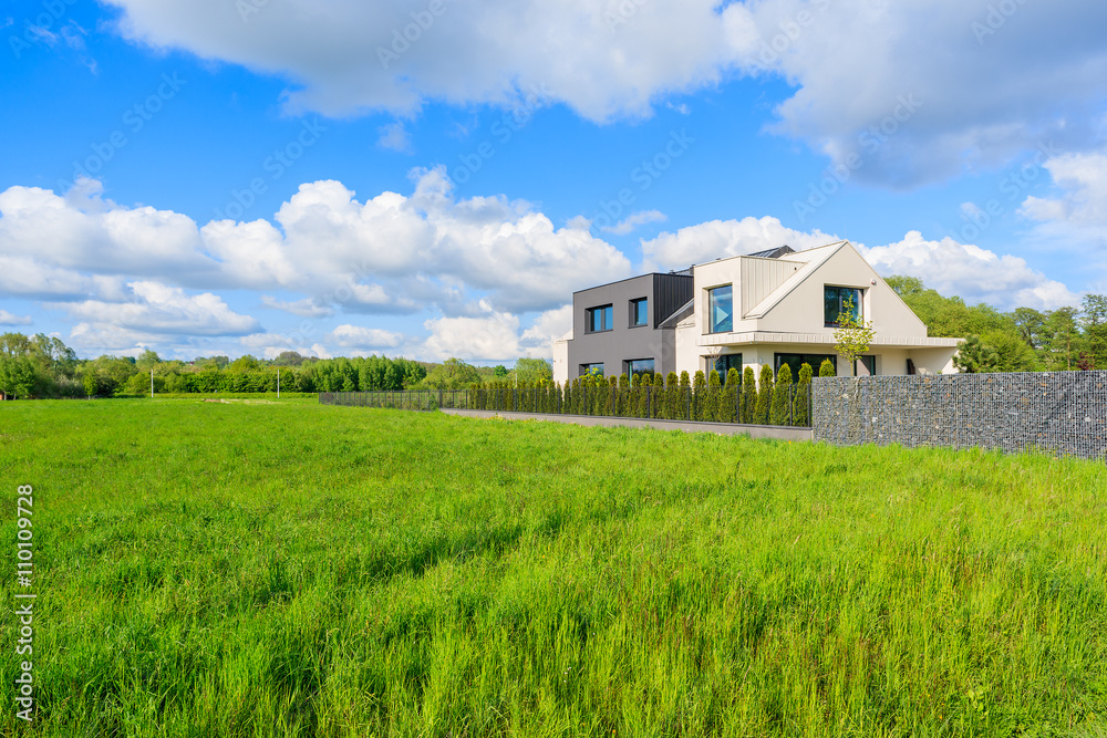 Modern house on green meadow in rural landscape of Krakow, Poland Modern house on green meadow in rural landscape of Krakow, Poland
